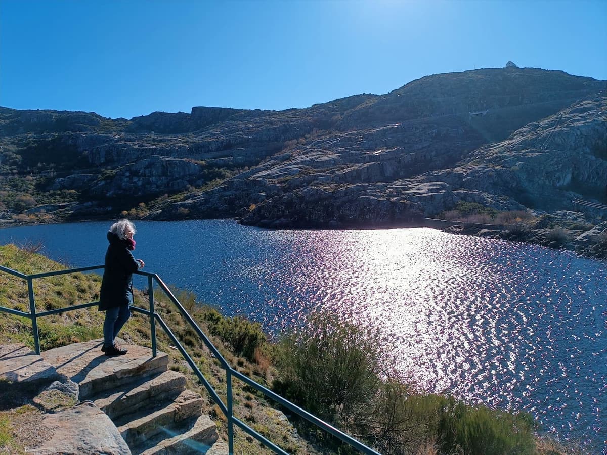 Um visitante no miradouro sobre a Lagoa Comprida, com sol na água