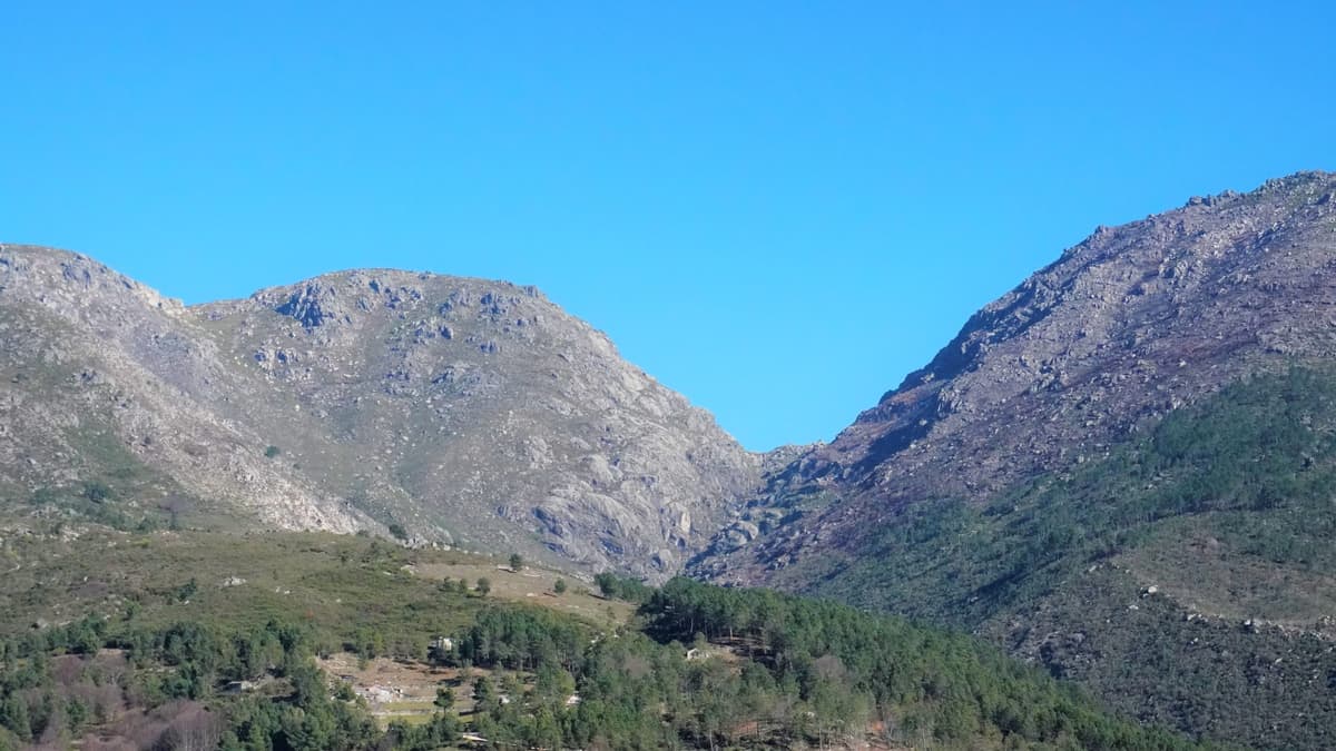 Encostas de granito sobre uma aldeia encaixada no pinhal